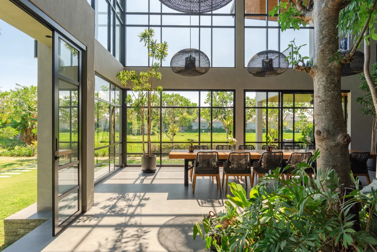 Sunset through the glass wall, the dining table and garden atrium