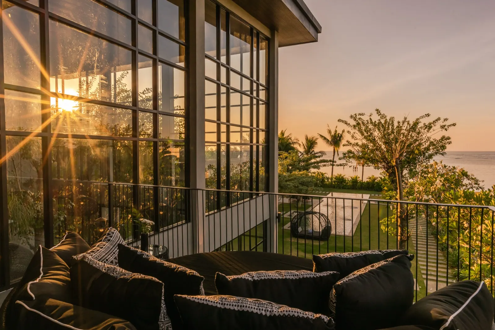 The upstairs balcony daybed at sunset, pool and sea below